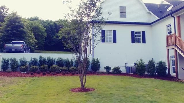 A large white house with a lush green lawn in front of it.