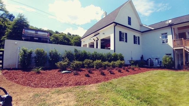 A large white house with a large lawn in front of it.