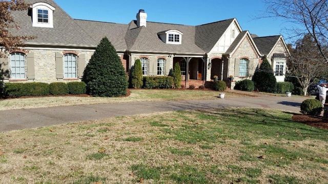 A large house with a lot of grass in front of it