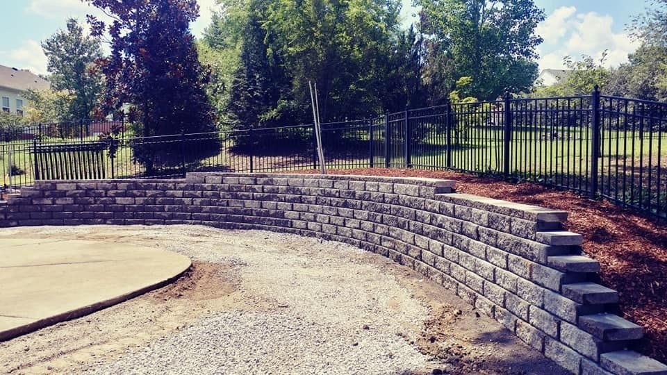 A brick wall is being built in the backyard of a house.