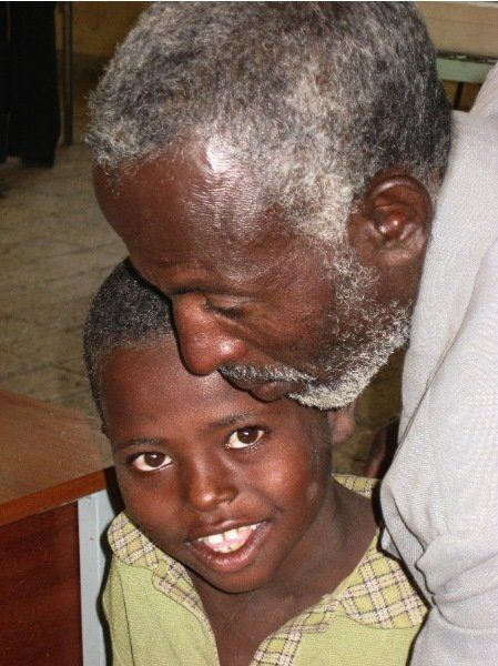 A man with a beard kisses a child on the forehead
