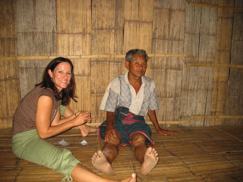 A man and a woman are sitting on a wooden floor.