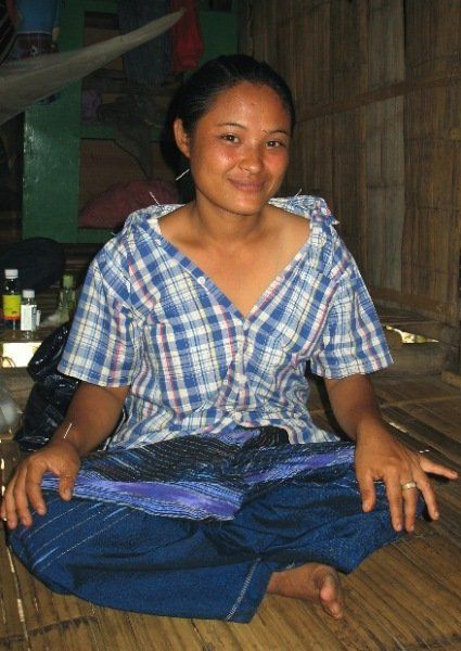 A woman in a plaid shirt sits on the floor with her legs crossed