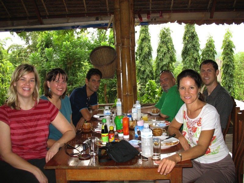 A group of people sitting around a table with bottles on it