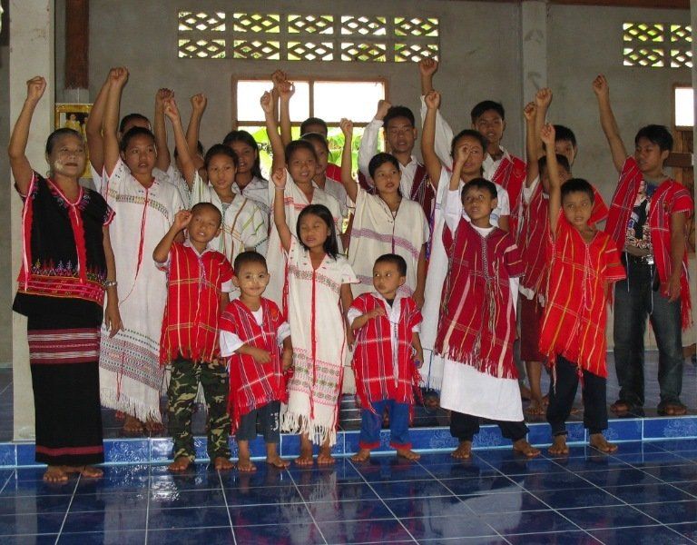 A group of people are posing for a picture with their hands in the air