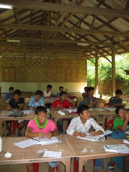 A group of children are sitting at tables in a classroom