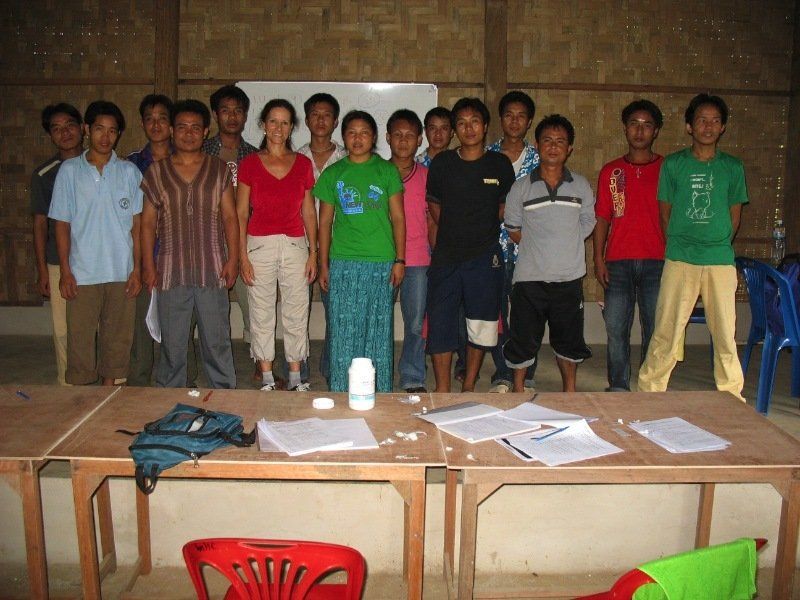 A group of people standing in front of a table with papers on it