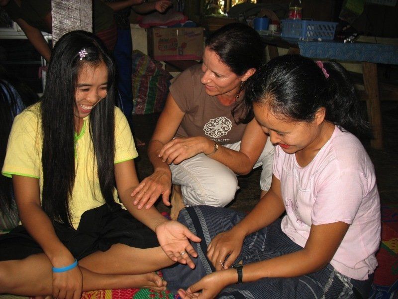 A group of girls are sitting on the floor playing with their hands