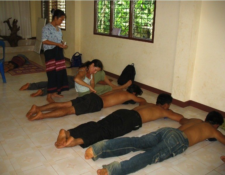 A group of people laying on the floor getting a massage