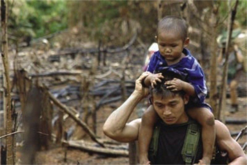 A man is carrying a small child on his shoulders