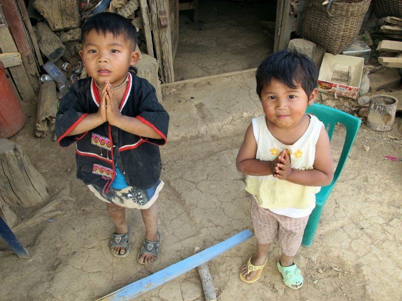 A boy and a girl standing next to each other with their hands folded