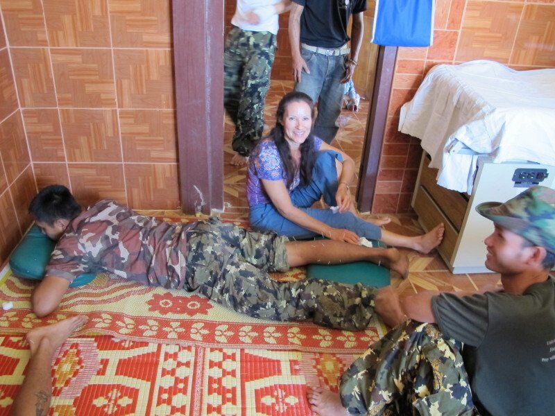 A group of people are laying on a rug with the letter h on it