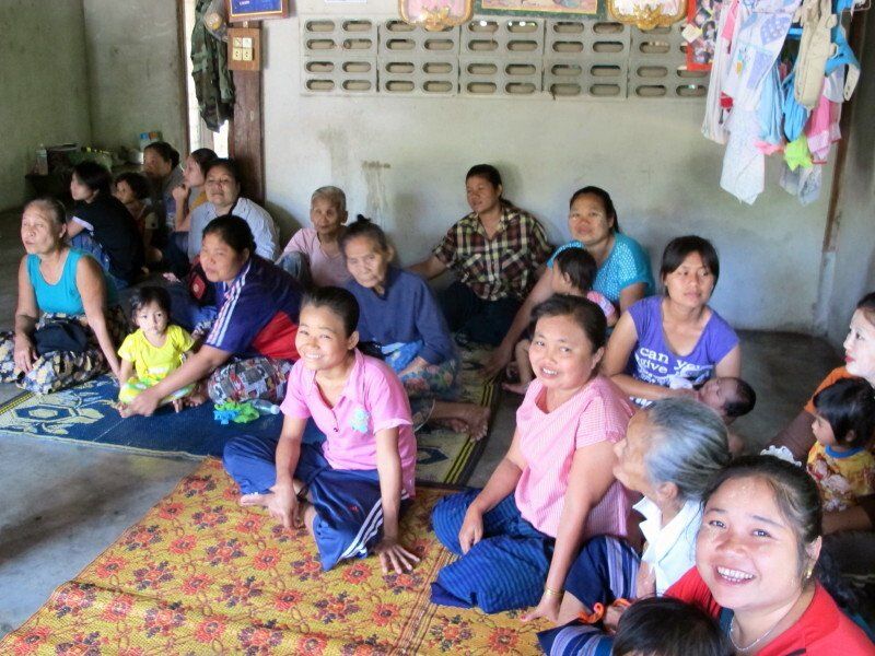 A group of people are sitting on the floor and smiling