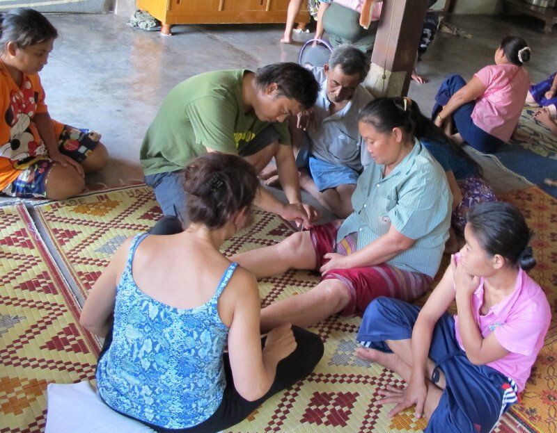 A group of people are sitting on a rug and one of them is wearing a shirt that says ' patagonia ' on it