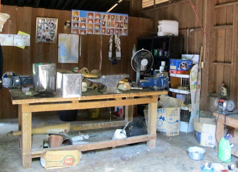 A messy room with a table and a fan