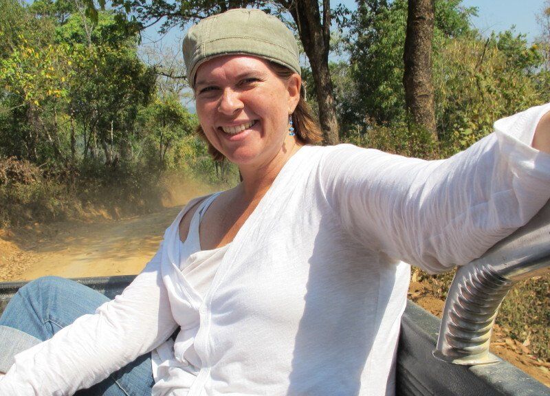 A woman wearing a hat and a white shirt is smiling