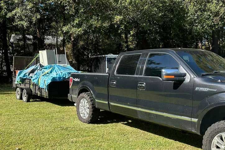 black pickup truck is towing a trailer 