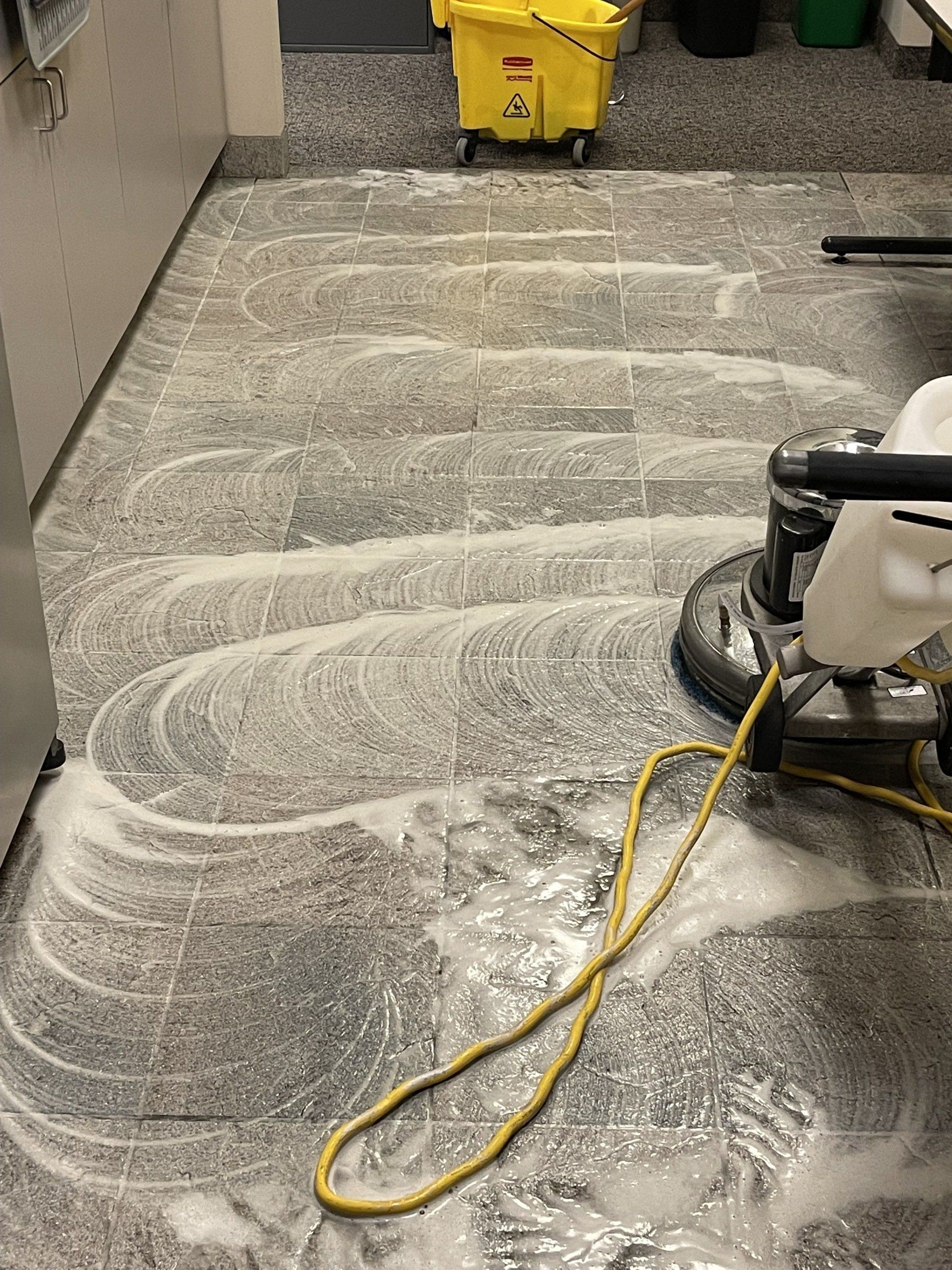 A mop is being used to clean a tile floor.