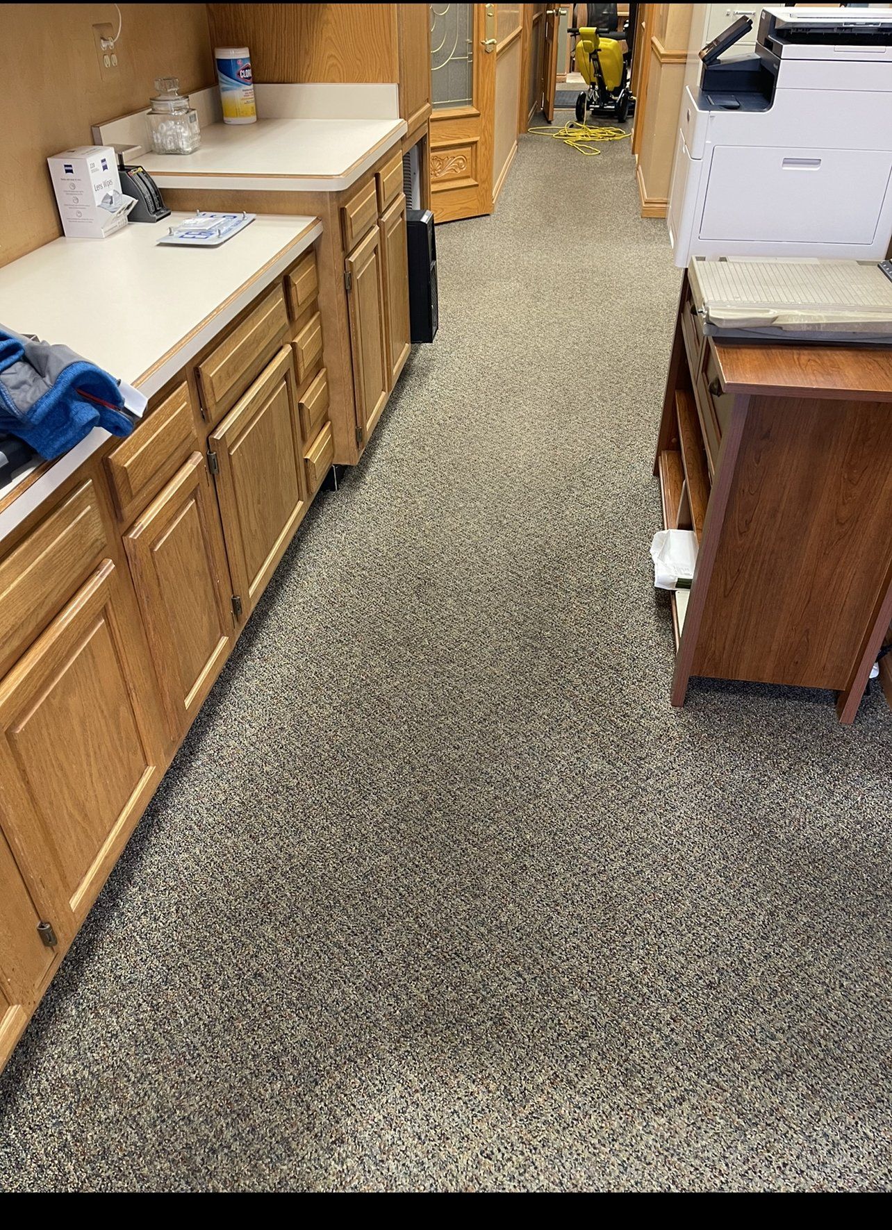 A kitchen with wooden cabinets and a gray floor