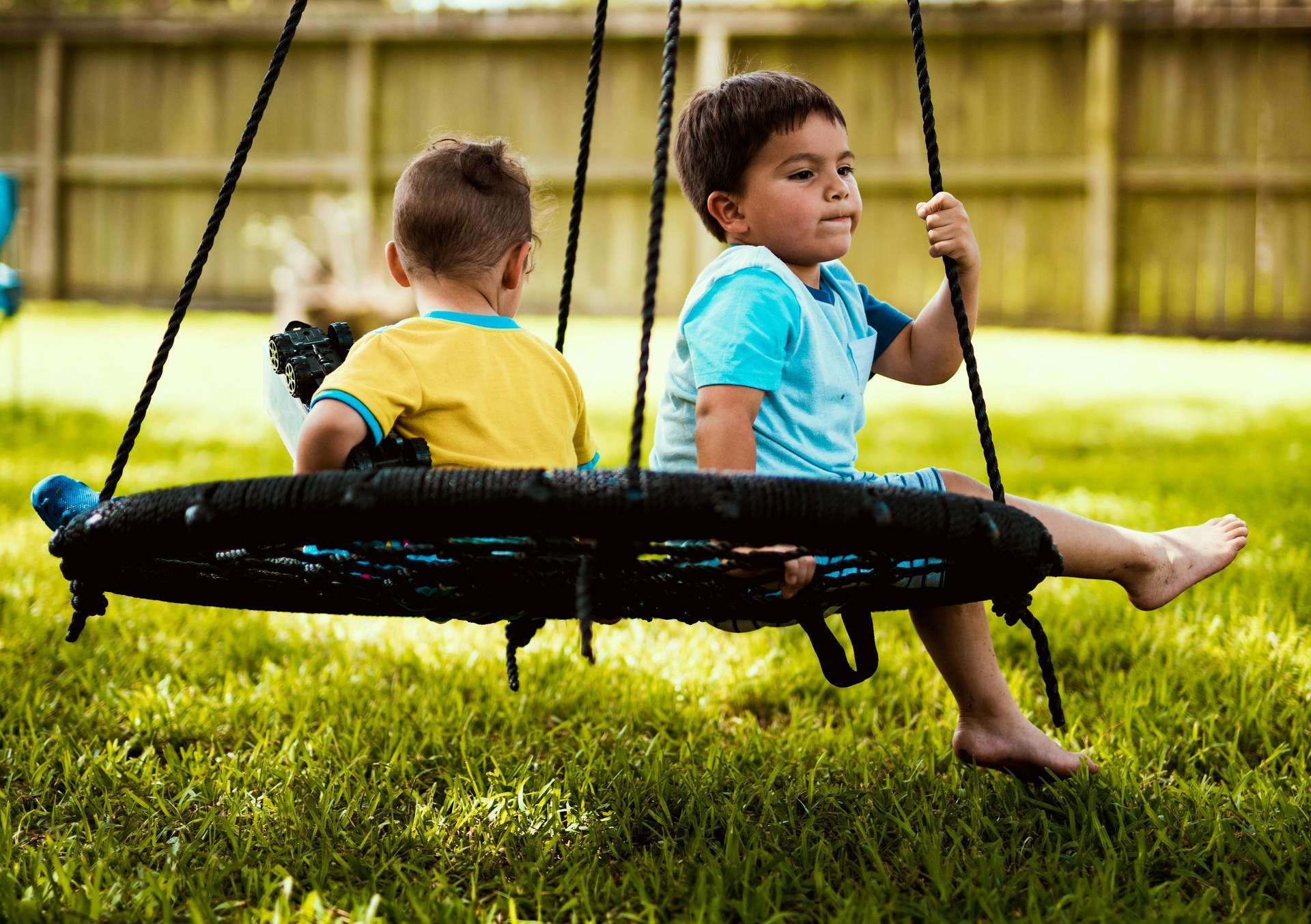 kids on swing on green lawn