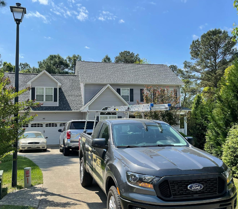 A ford truck is parked in front of a house.