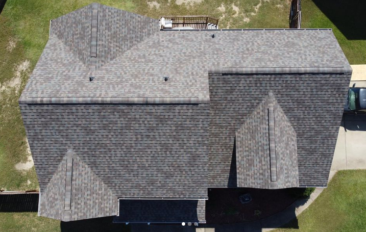 An aerial view of a large house with a gray roof.