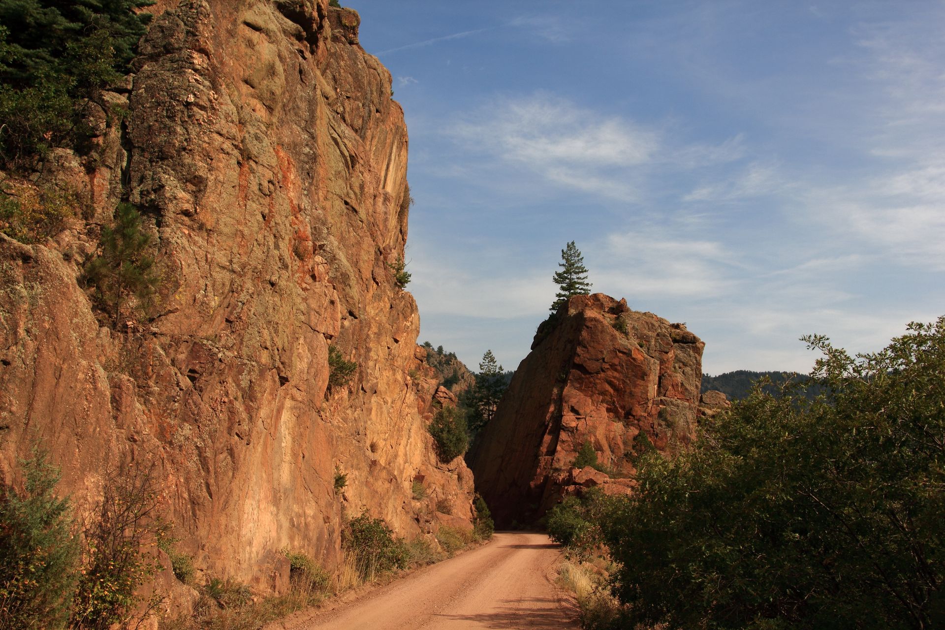 A dirt road going through a canyon with rocks on both sides