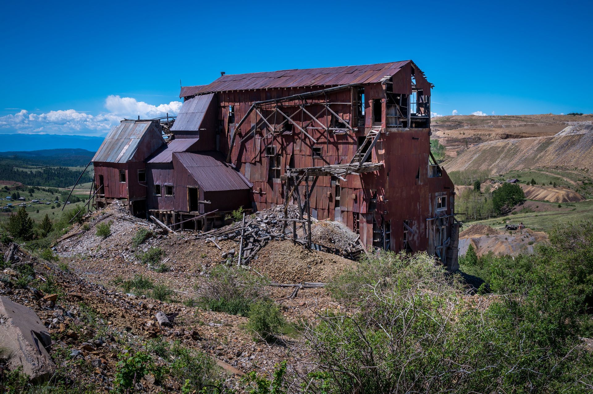 An old rusty building is sitting on top of a hill.