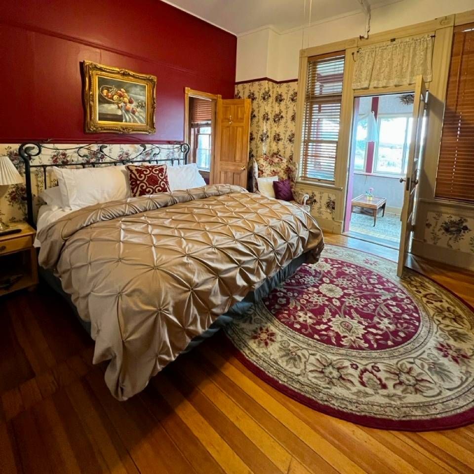 A bedroom with a large bed and a rug on the floor