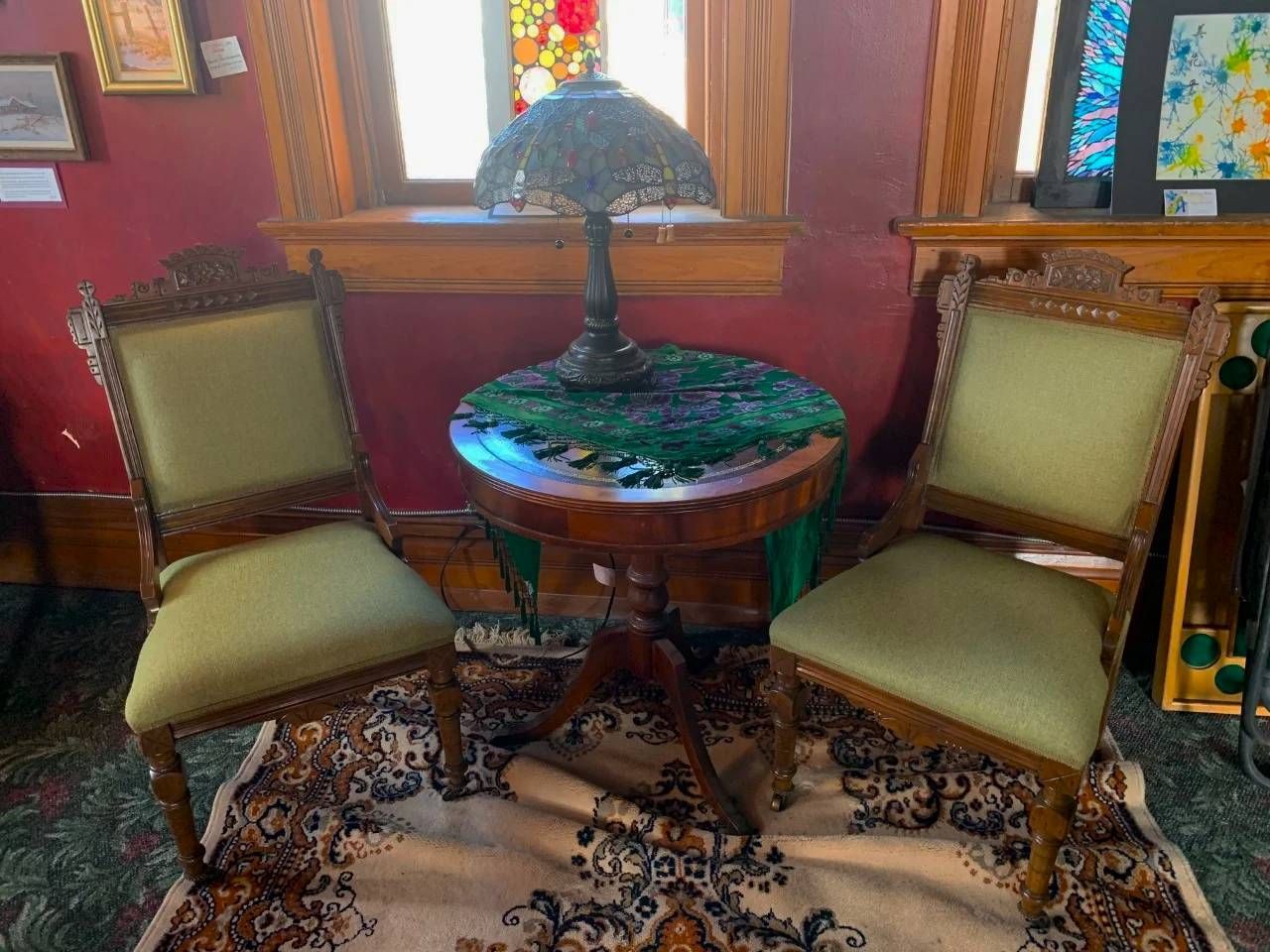 Two chairs and a table with a lamp in a room.