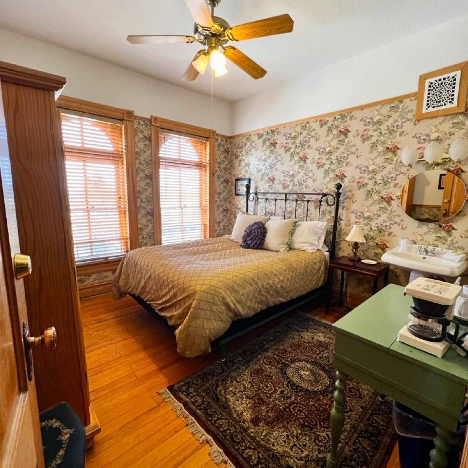 A bedroom with a bed and a ceiling fan