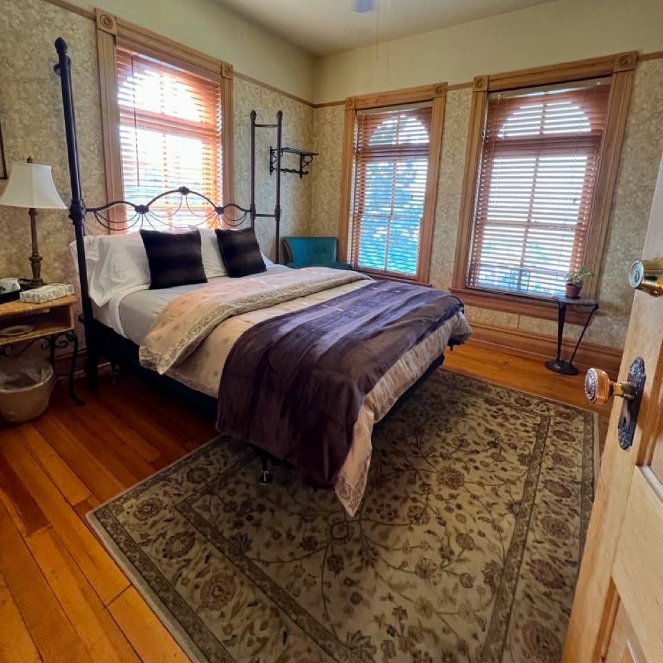 A bedroom with a king size bed and a rug