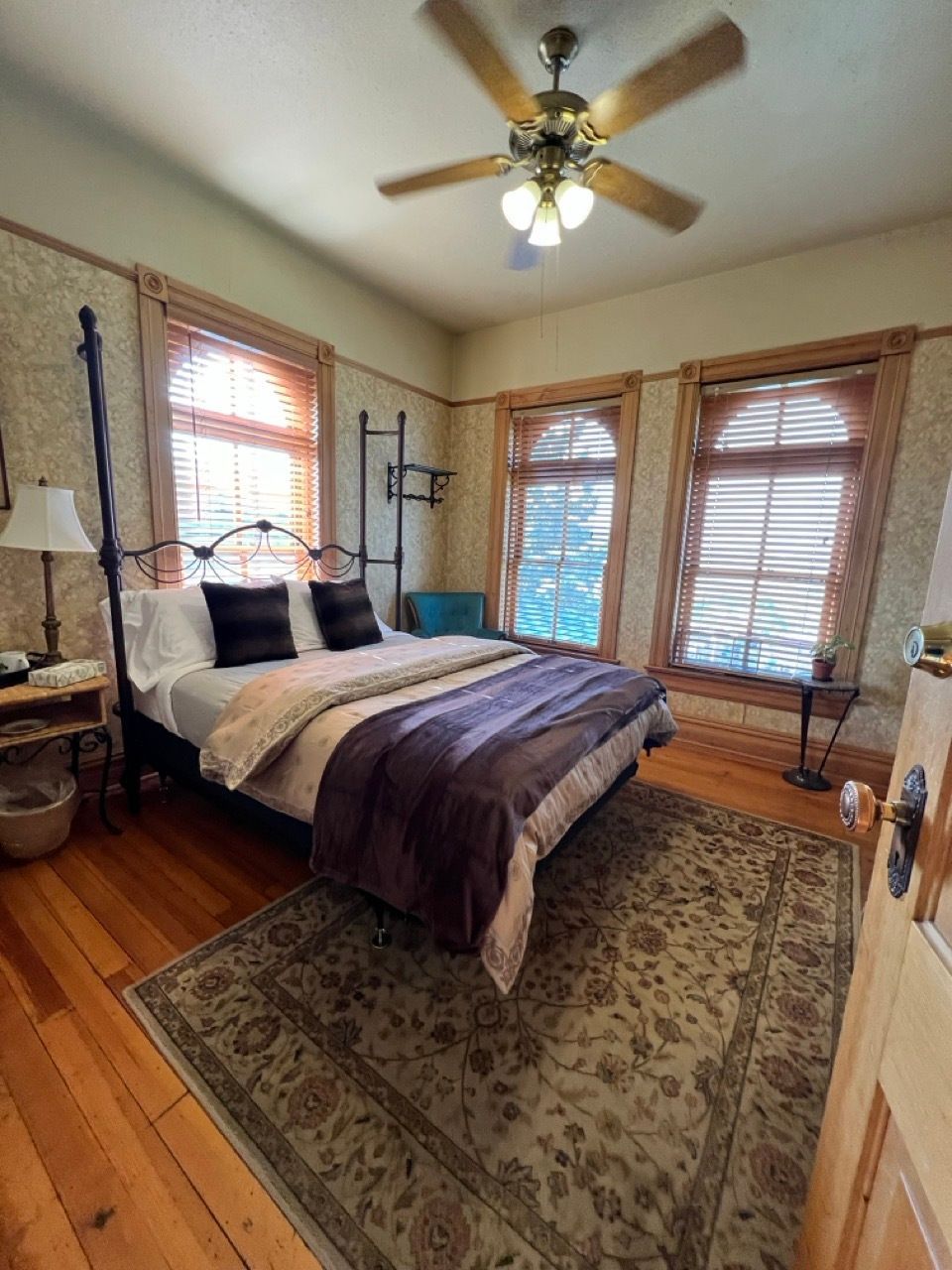 A bedroom with a bed and a ceiling fan