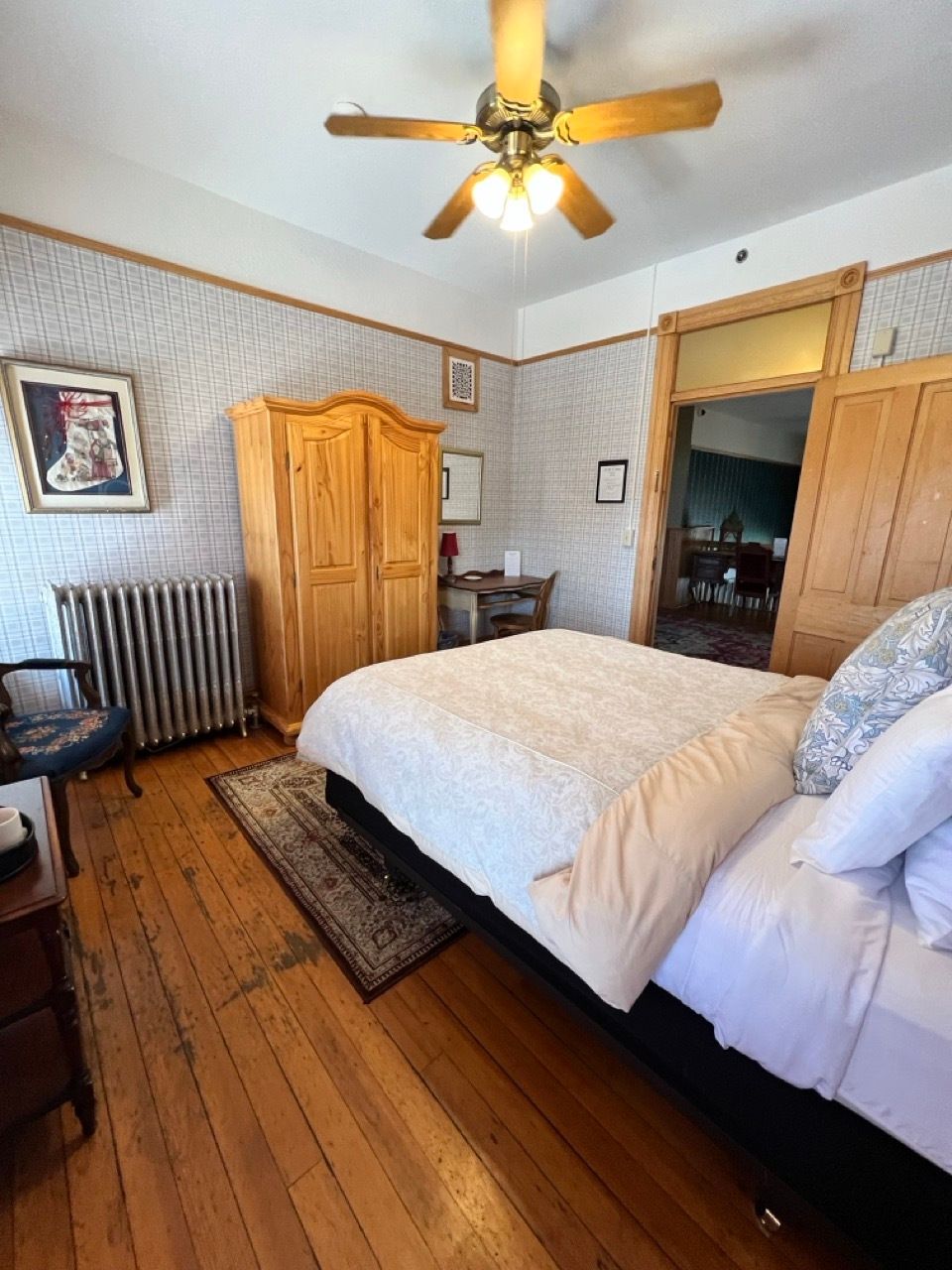 A bedroom with a large bed and a ceiling fan