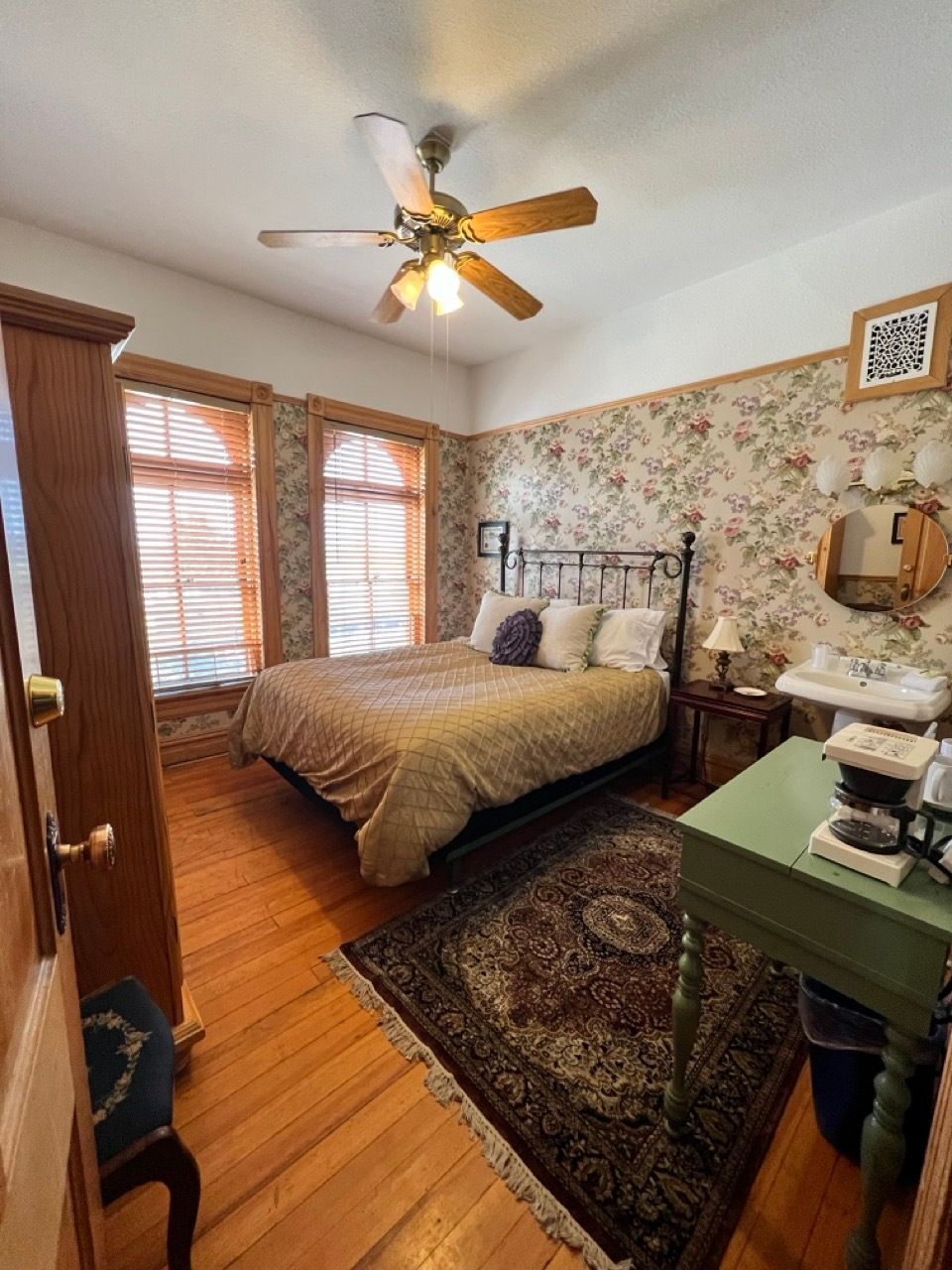 A bedroom with a bed and a ceiling fan