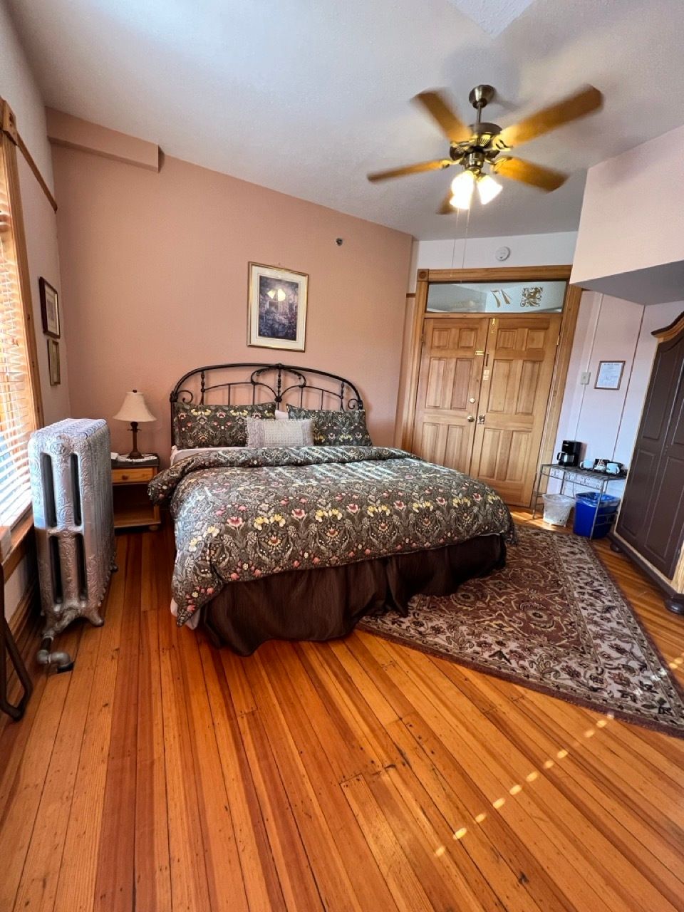 A bedroom with a large bed and a ceiling fan