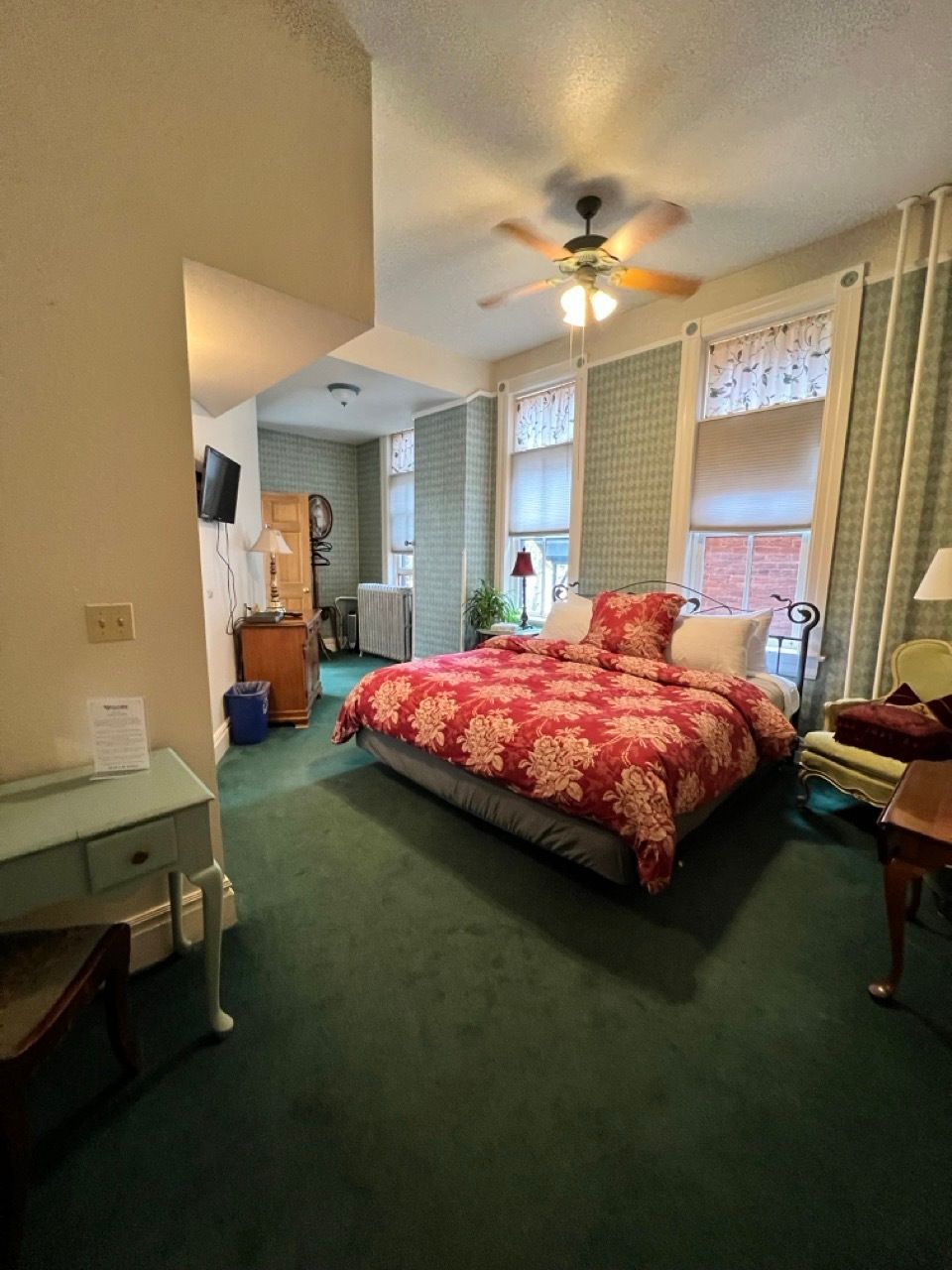 A hotel room with a large bed and a ceiling fan