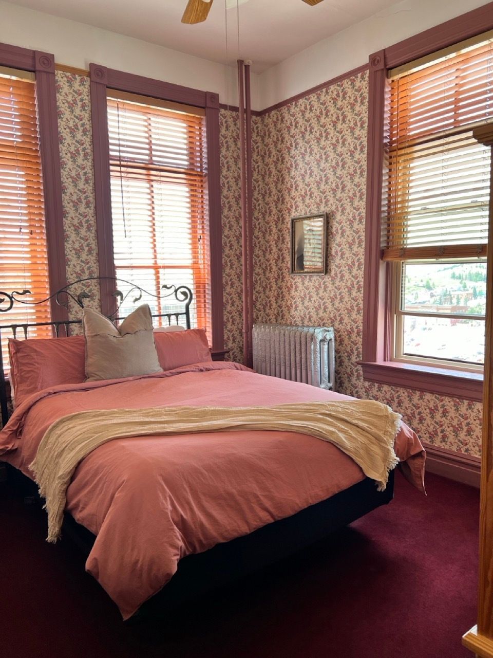 A bedroom with a bed and a window with blinds