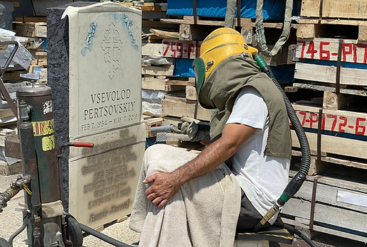Worker preparing a tombstone to remove polish