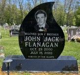 Teardrop-shaped memorial with laser-etched image of the deceased wearing a bow-tie. On polished black granite.