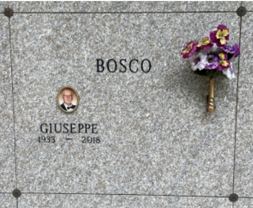 Mausoleum door with a small portrait and flowers.