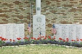 A war memorial with several stone walls inscribed with the names of service members.