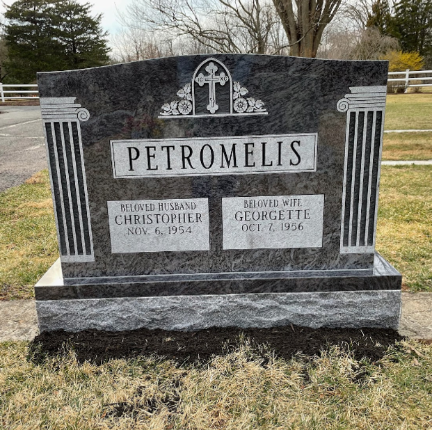 A double upright black granite headstone. Two decorative columns, featuring vertical fluting and carved capitals, flank the central panel.