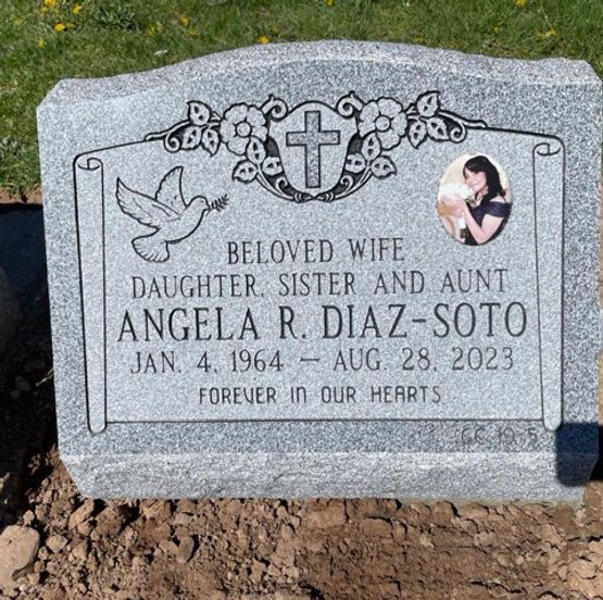 A single slant gravestone with a cross and floral scrollwork, a dove with an olive branch, and an oval photo portrait.