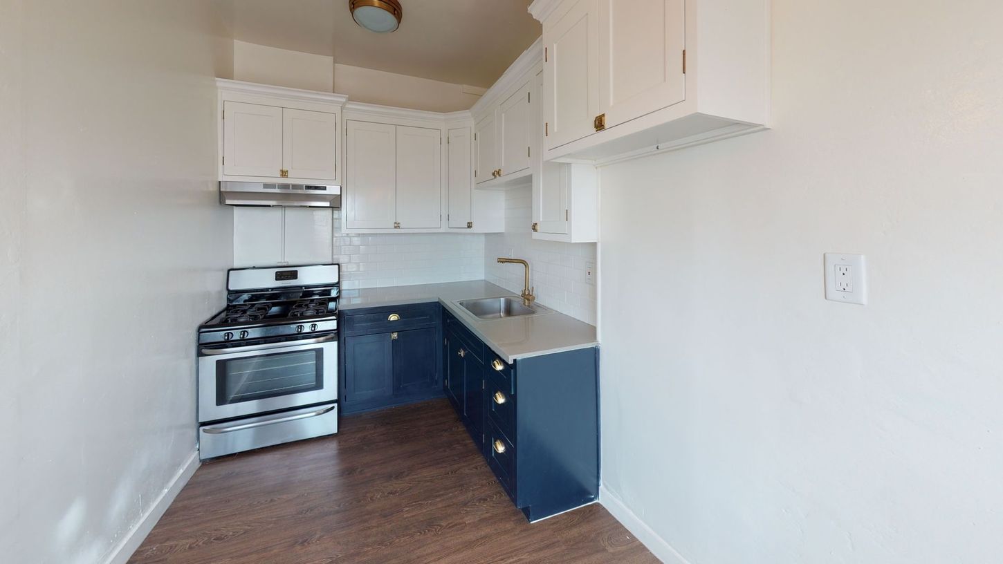 Kitchen with blue cabinets, white walls, and stainless steel appliances.