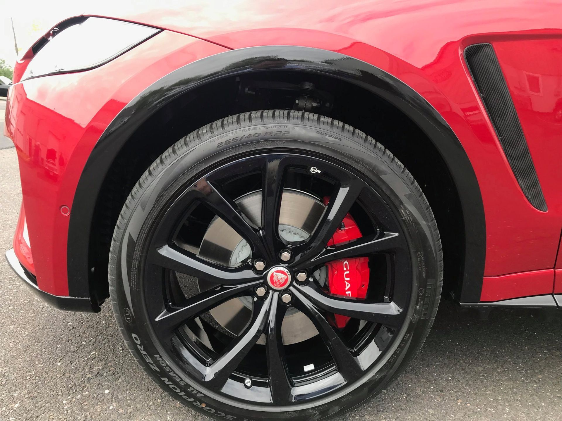 Black Ice Details & Coatings | close up of a red car with black wheels and a red brake caliper.