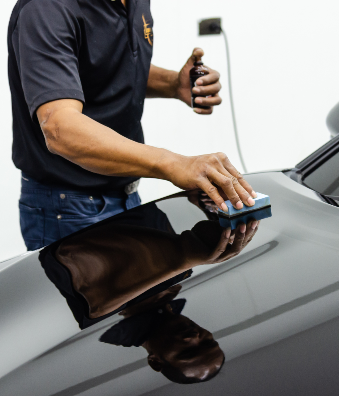 Black Ice Details & Coatings | man is polishing the hood of a black car