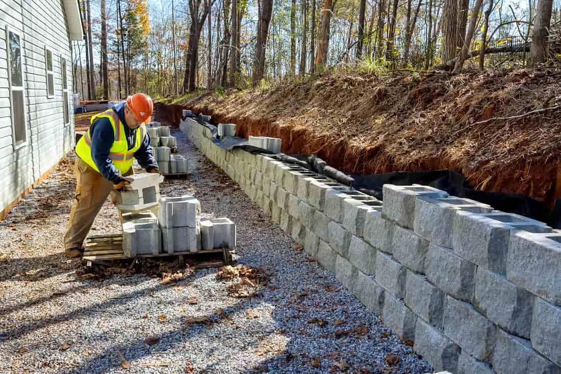 a concrete contractor building a concrete retaining wall build with cinder blocks