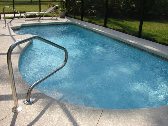 a concrete pool deck with a pool