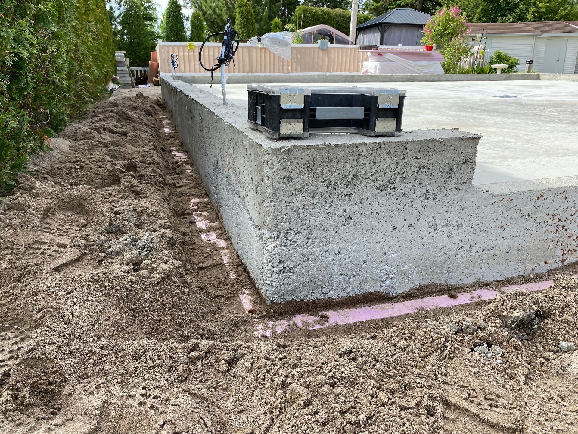 Un mur de béton est en train d'être construit sur un terrain en terre.